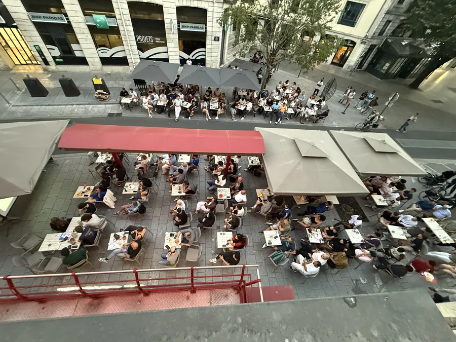 Vue en surplomb de la terrasse du Cristal et de ses stores rouges, en centre-ville de Pau